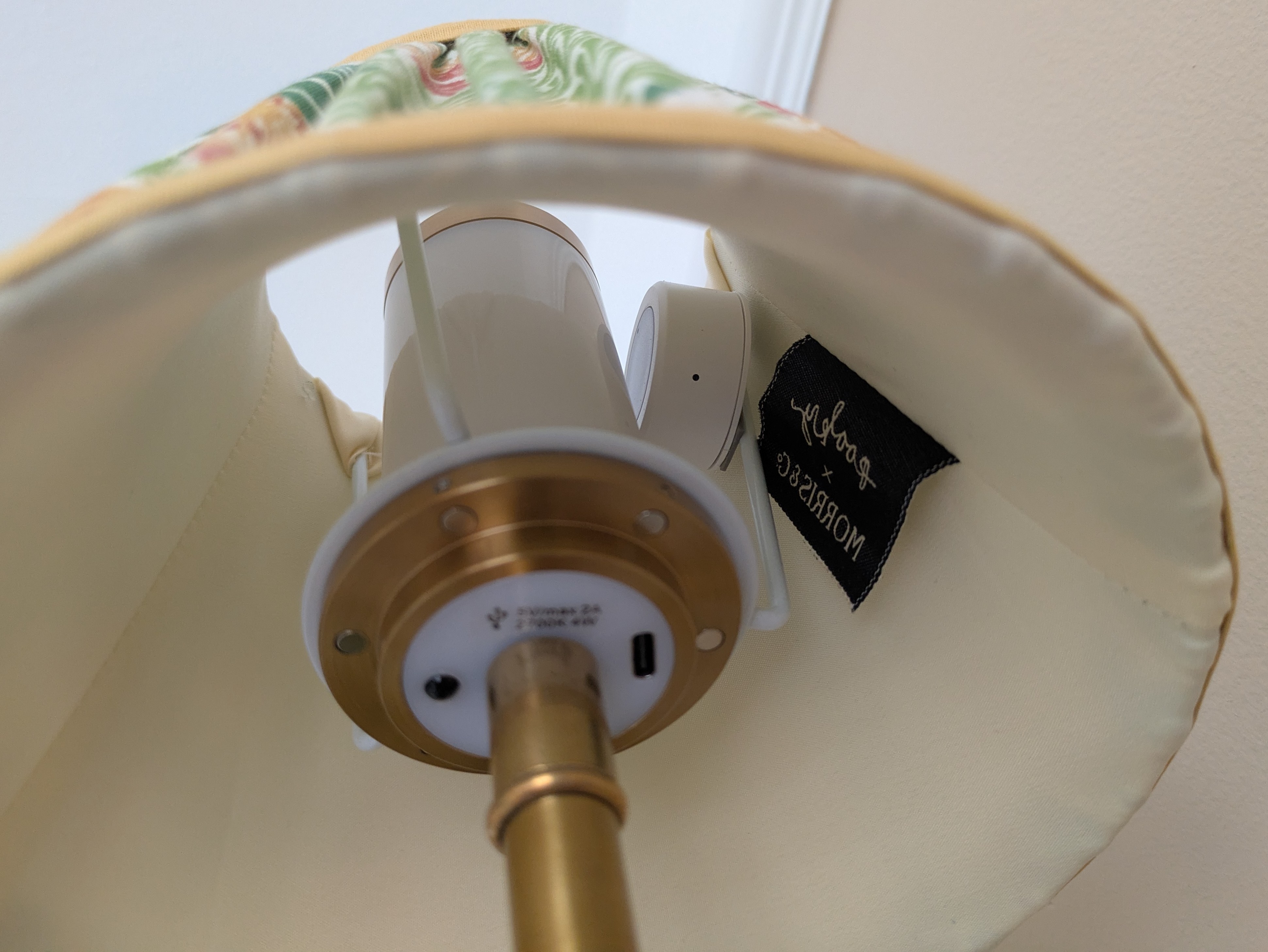 Looking up inside the lampshade: a small round white light sensor is taped beside the white cylindrical bulb.